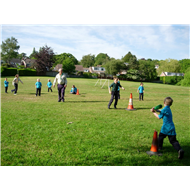 A child hitting the ball in rounders 